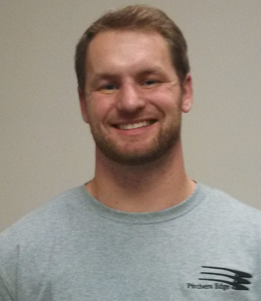 A man in grey shirt smiling for the camera.