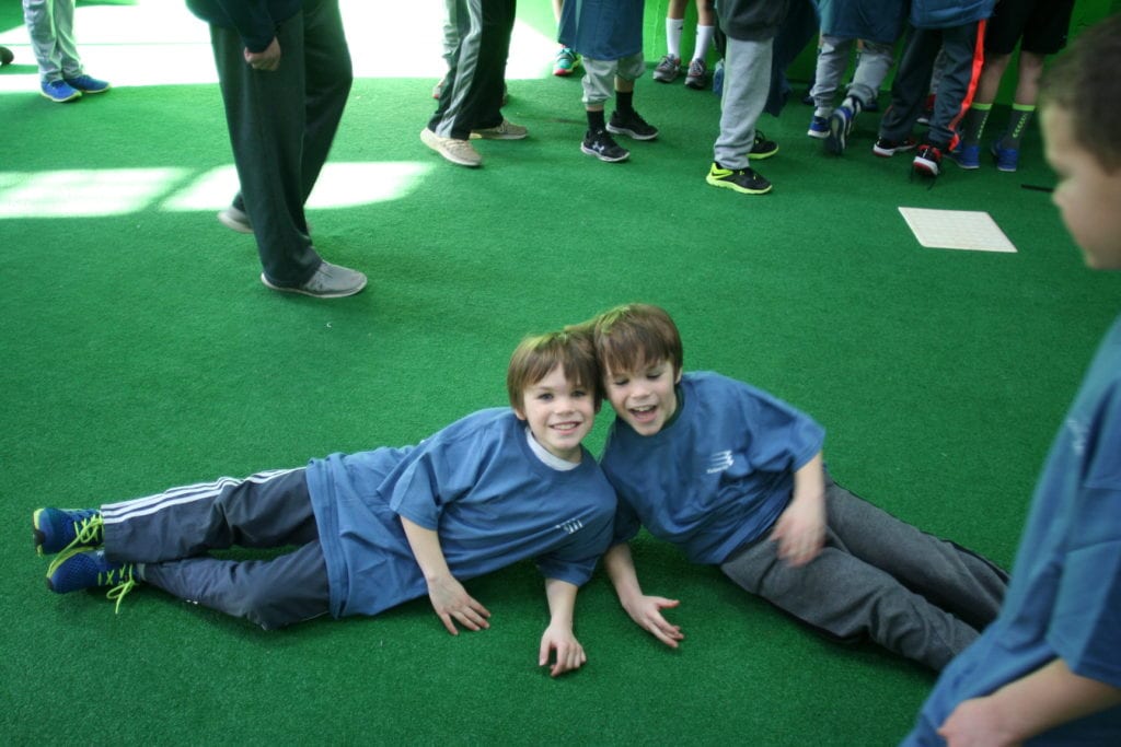 Two boys laying on the ground in a room