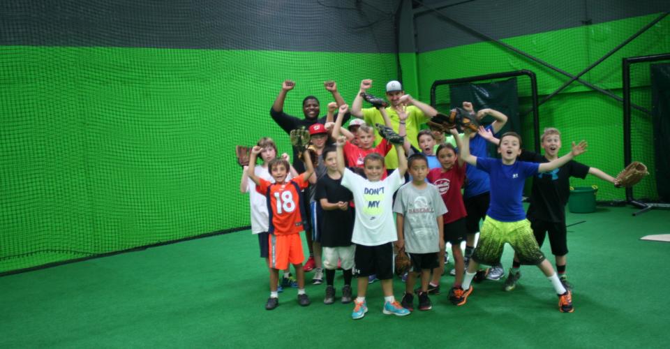 A group of people posing for the camera in front of green walls.