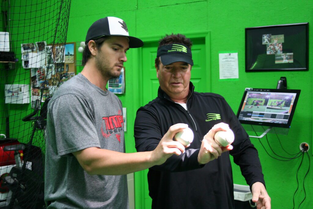 Two men holding baseball balls in their hands.