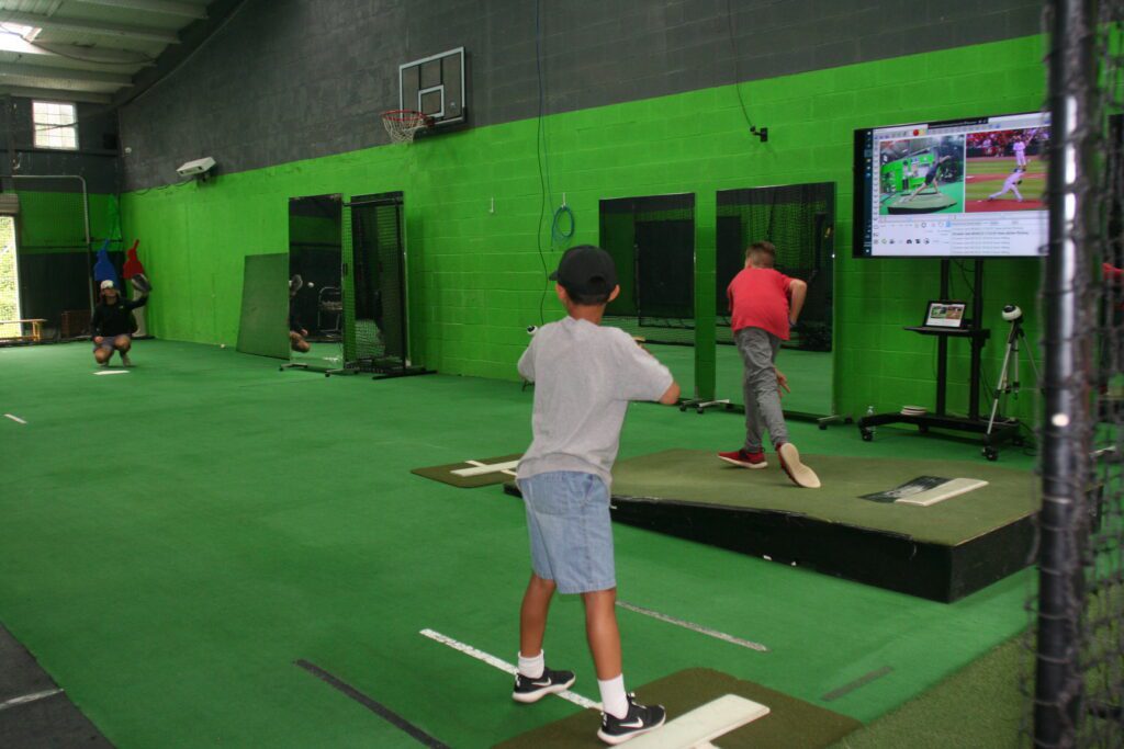 A boy is playing baseball on the video game.