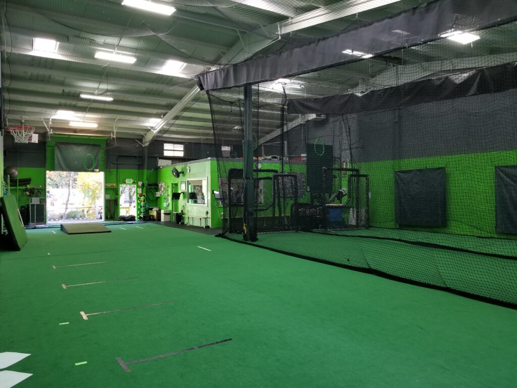 A green room with batting cages and other equipment.