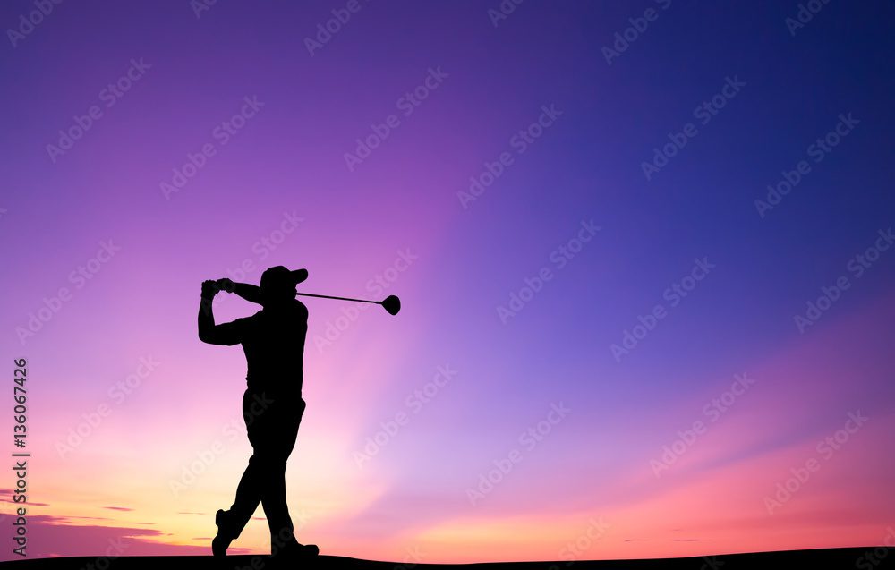 A man swinging at the sunset with his golf club.